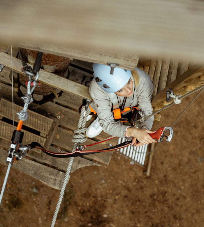 En tjej kopplar om sin skerhetsutrustning p hghjdsbanan